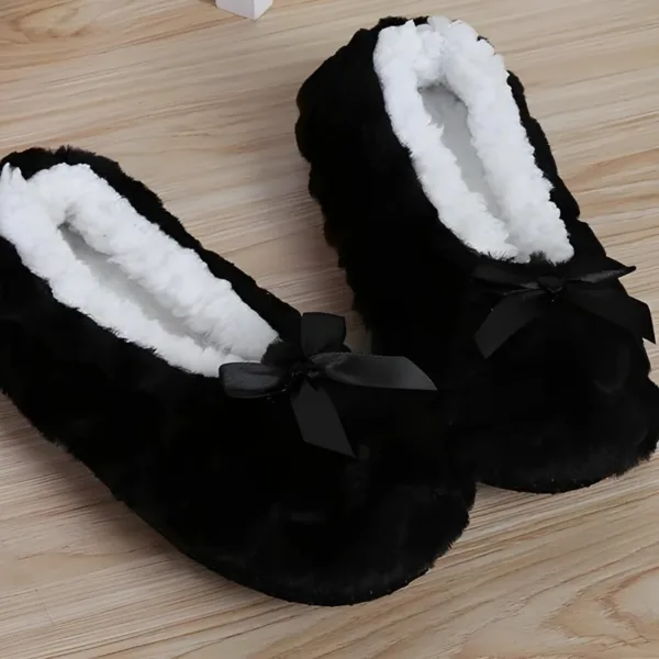 Black fluffy slippers with a cute bow detail, perfect for cozy days at home.