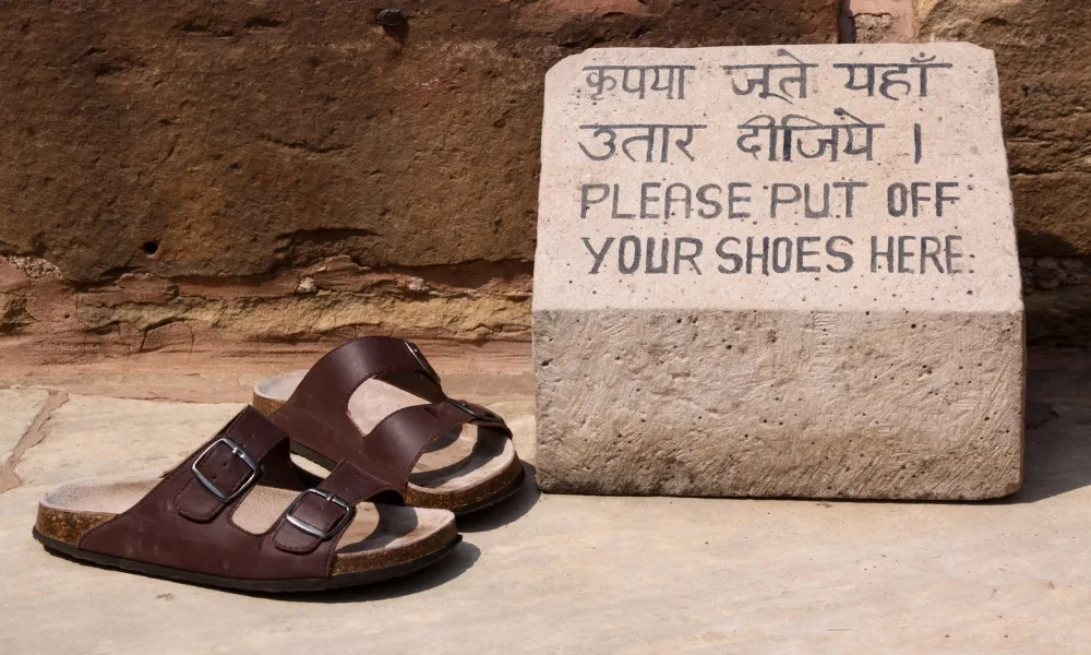 Sign to leave shoes on the ground near Hindu temple